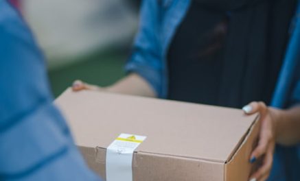 Versand Dienstleister übergibt ein Paket an einen Empfänger